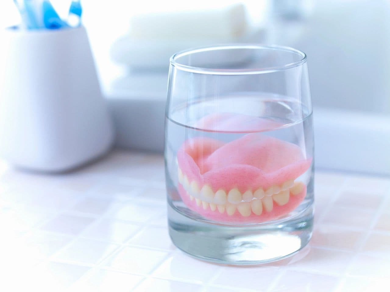 Dentures soaking in a clear glass