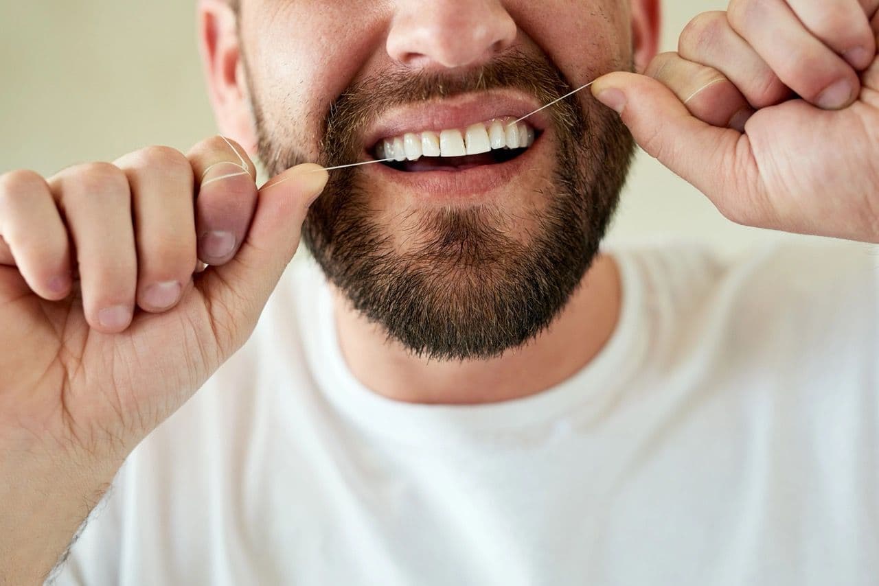 A man flossing his teeth