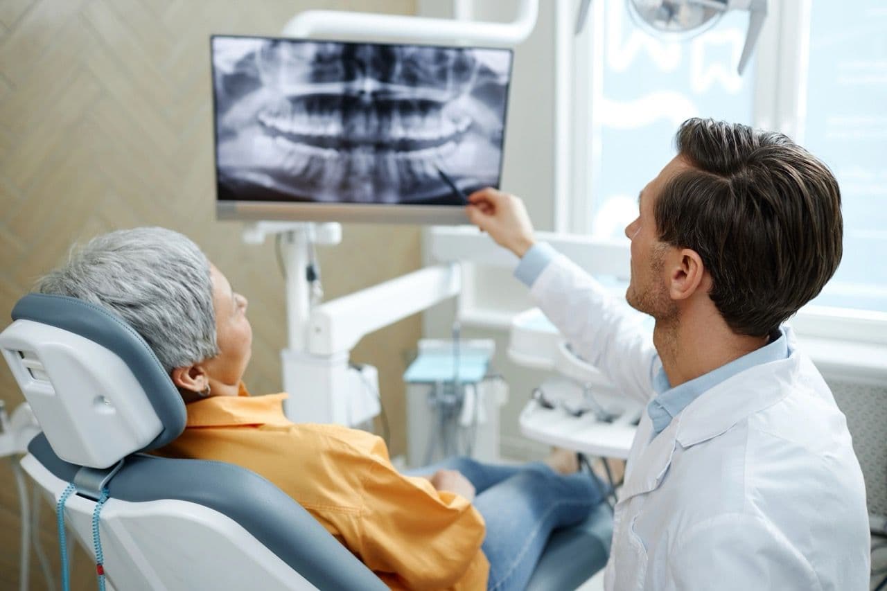 Photo of a dentist showing X-rays to a patient